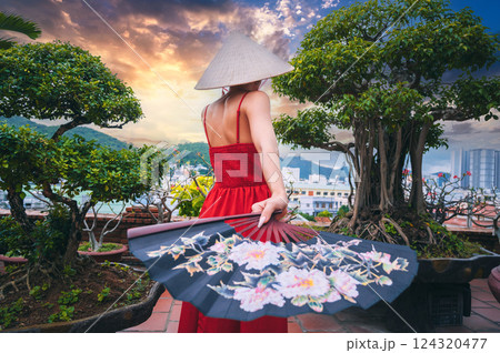 back of female tourist traveler in Vietnamese non la hat and fan is traveling in Vietnam in Asia back of female tourist traveler in Vietnamese non la hat and fan is traveling in Vietnam in Asia 124320477