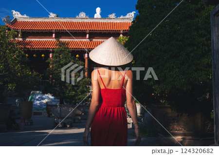 back of a Vietnamese tourist woman in Non La hat at a pagoda temple in Vietnam on trip to Asia back of a Vietnamese tourist woman in Non La hat at a pagoda temple in Vietnam on trip to Asia 124320682