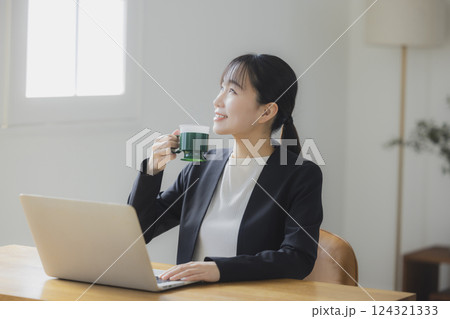仕事中にコーヒーを飲む女性 仕事中にコーヒーを飲む女性 124321333