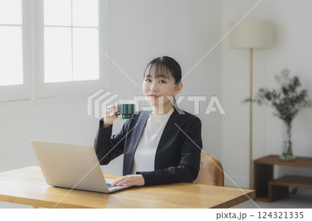 仕事中にコーヒーを飲む女性 仕事中にコーヒーを飲む女性 124321335
