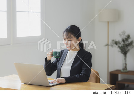 仕事中にコーヒーを飲む女性 仕事中にコーヒーを飲む女性 124321338