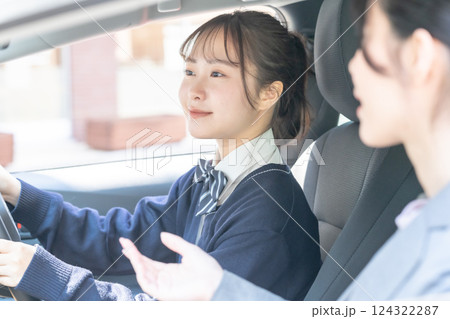 教習所で教官に運転を習う女子高生 教習所で教官に運転を習う女子高生 124322287
