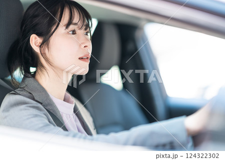 車を運転するスーツ姿の若い女性 124322302