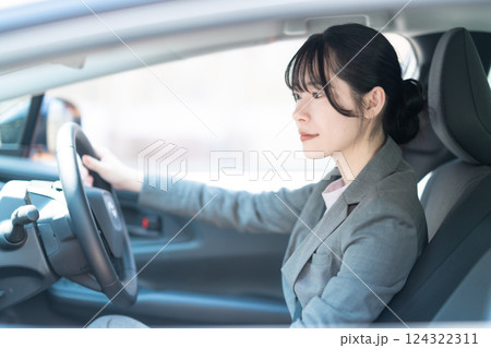 車を運転するスーツ姿の若い女性 124322311