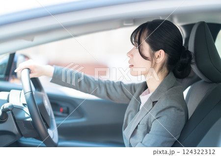 車を運転するスーツ姿の若い女性 車を運転するスーツ姿の若い女性 124322312