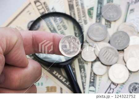 A one-ruble Russian coin is held on the finger. 124322752