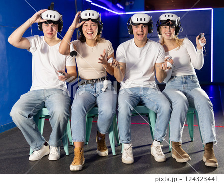 Friends playing video games in virtual reality headsets 124323441