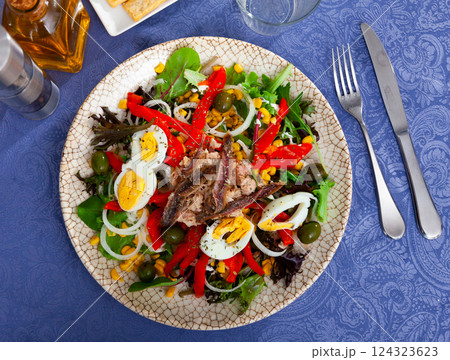 Corn, olive, anchovy, pepper, lettuce salad served on plate Corn, olive, anchovy, pepper, lettuce salad served on plate 124323623