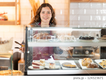 Woman seller offering pastries in a cafe 124323671