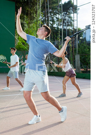 Young frontenis player swinging racquet to hit ball on outdoor court 124323707