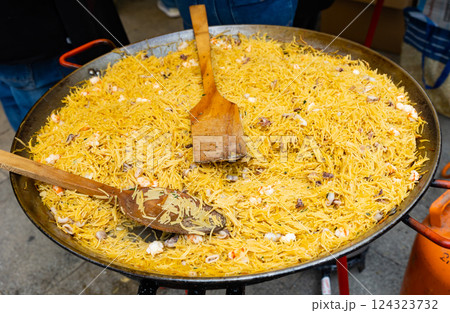 Paellera with Valencian seafood fideua prepared during street festival Paellera with Valencian seafood fideua prepared during street festival 124323732