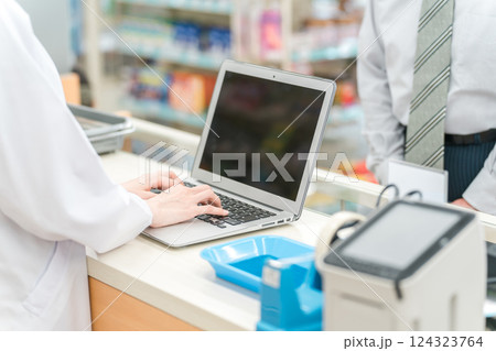 薬局でノートパソコンを使いながら相談を受ける薬剤師・調剤師 薬局でノートパソコンを使いながら相談を受ける薬剤師・調剤師 124323764