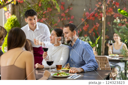 Waiter talking to restaurant guests - taking orders for food and drinks Waiter talking to restaurant guests - taking orders for food and drinks 124323823
