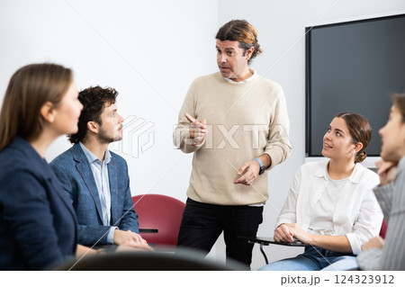 Knowledgeable professor explaining subject to classroom full of students 124323912