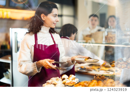 Girl saleswoman works in cafeteria bakery shop 124323919