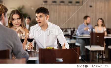 Couple and adult man eating and talking in restaurant 124323949