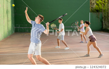 Young man playing frontenis at open-air fronton court in summer 124324072