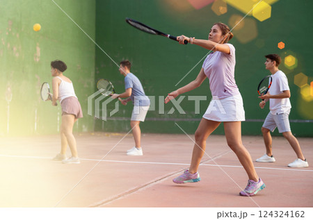 Expressive resolved fit girl playing frontenis ball friendly match on court 124324162