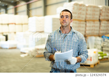 Engineer or foreman holding documents and checking inventory or job details indoor. Engineering site and working with technology concept Engineer or foreman holding documents and checking inventory or job details indoor. Engineering site and working with technology concept 124324374