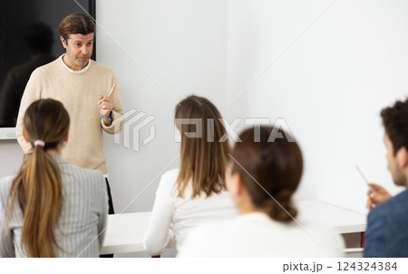 Knowledgeable professor explaining subject to classroom full of students 124324384