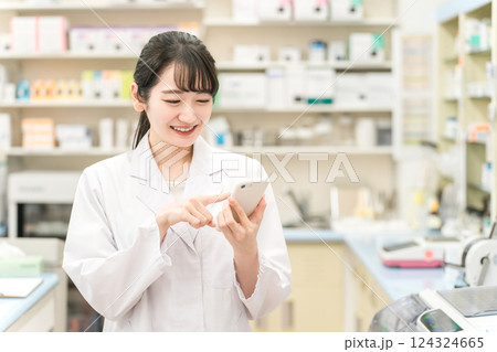 スマホを持つ薬剤師の女性（お薬手帳・アプリ・処方箋・モバイル） 124324665