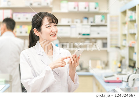 スマホを持つ薬剤師の女性（お薬手帳・アプリ・処方箋・モバイル） 124324667