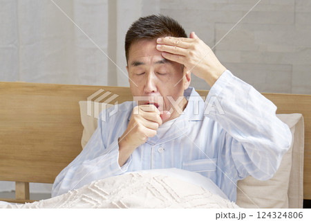 咳をするパジャマを着た中年の男性 124324806