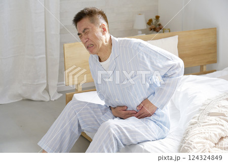 腹痛のパジャマを着た中年の男性 腹痛のパジャマを着た中年の男性 124324849