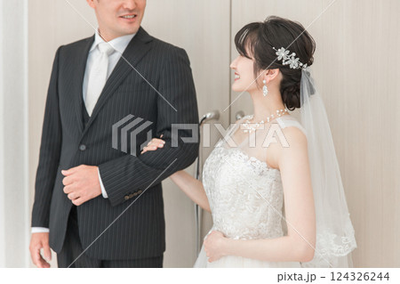 結婚式場で新郎の待つチャペルまでバージンロードを歩く新婦・花嫁の女性と父親 124326244