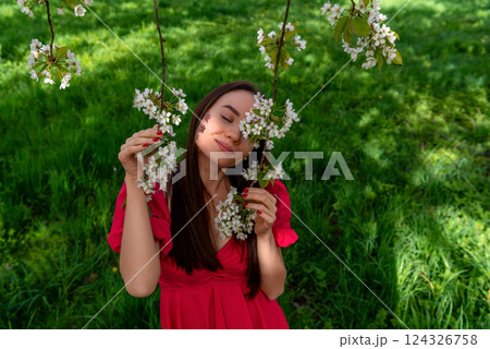 Portrait with a smiling serene woman in a cherry tree orchard Portrait with a smiling serene woman in a cherry tree orchard 124326758