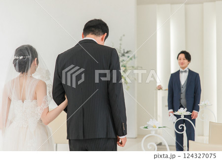 結婚式場・チャペルでバージンロードを歩く新婦を待つ新郎・花婿の男性 124327075
