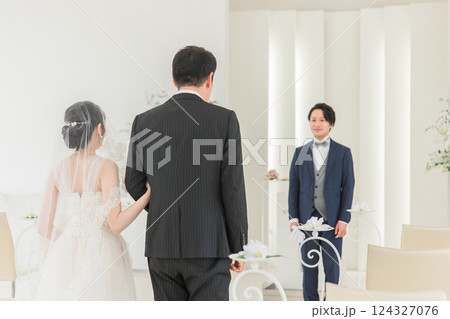 結婚式場・チャペルでバージンロードを歩く新婦を待つ新郎・花婿の男性 結婚式場・チャペルでバージンロードを歩く新婦を待つ新郎・花婿の男性 124327076