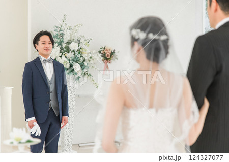 結婚式場・チャペルでバージンロードを歩く新婦を待つ新郎・花婿の男性 124327077