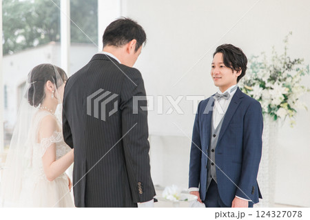 結婚式場・チャペルでバージンロードを歩く新婦を待つ新郎・花婿の男性 結婚式場・チャペルでバージンロードを歩く新婦を待つ新郎・花婿の男性 124327078