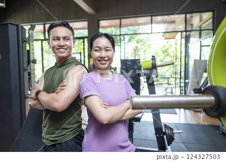 Chinese east asian woman and indonesian southeast asian man working out together at the gym. Fitness exercise and healthy lifestyle concept Chinese east asian woman and indonesian southeast asian man working out together at the gym. Fitness exercise and healthy lifestyle concept 124327503