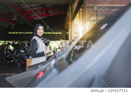 Arab middle eastern muslim women training on treadmill machine at the gym. Fitness exercise and healthy lifestyle concept Arab middle eastern muslim women training on treadmill machine at the gym. Fitness exercise and healthy lifestyle concept 124327531