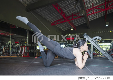 Chinese east asian woman working out and stretching in a yoga class at the gym. Fitness exercise and healthy lifestyle concept 124327746
