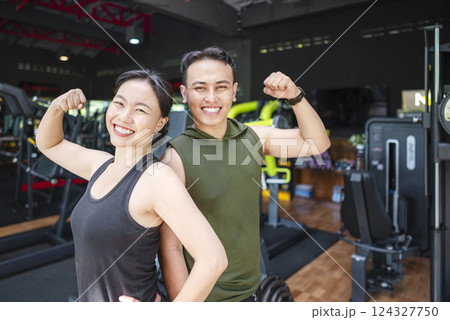 Chinese east asian woman and indonesian southeast asian man working out together at the gym. Fitness exercise and healthy lifestyle concept Chinese east asian woman and indonesian southeast asian man working out together at the gym. Fitness exercise and healthy lifestyle concept 124327750