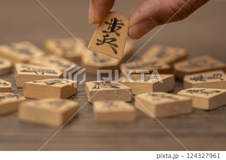 沢山の将棋の駒の中から一つをつまみ上げている素材写真 人選イメージ 沢山の将棋の駒の中から一つをつまみ上げている素材写真 人選イメージ 124327961