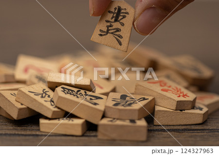 沢山の将棋の駒の中から一つをつまみ上げている素材写真 人選イメージ 沢山の将棋の駒の中から一つをつまみ上げている素材写真 人選イメージ 124327963