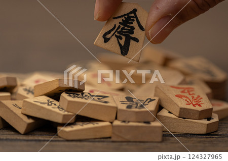 沢山の将棋の駒の中から一つをつまみ上げている素材写真 人選イメージ 沢山の将棋の駒の中から一つをつまみ上げている素材写真 人選イメージ 124327965