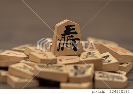沢山の将棋の駒の上に王将が立っている　権力者が弱いものを虐げているイメージ 124328185