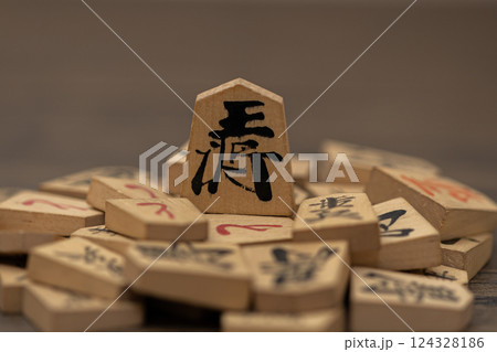 沢山の将棋の駒の上に王将が立っている　権力者が弱いものを虐げているイメージ 124328186