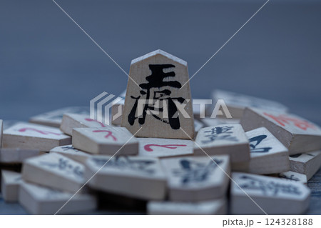 沢山の将棋の駒の上に王将が立っている　権力者が弱いものを虐げているイメージ 124328188