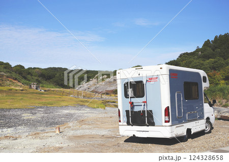 荒涼とした温泉が湧き出る岩肌とキャンピングカー 124328658