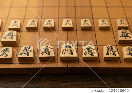 将棋盤の上に将棋の駒が並べられている 124328669