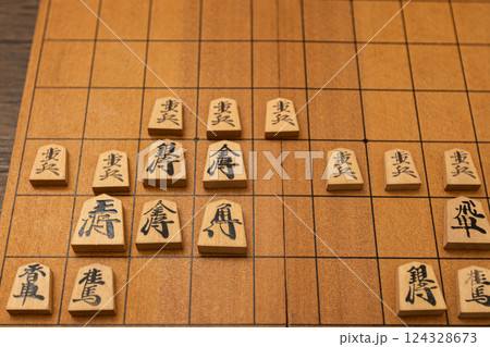 将棋盤の上に将棋の駒が並べられている　櫓囲いで戦っている 124328673