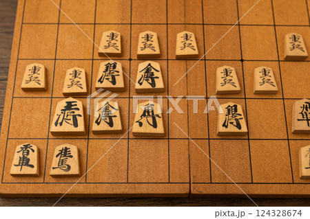 将棋盤の上に将棋の駒が並べられている　櫓囲いで戦っている 124328674