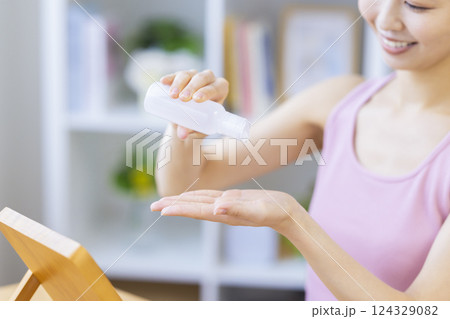 ビューティーイメージ　美容液を手に垂らす女性の手元 124329082