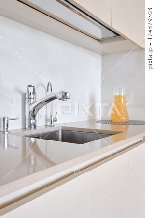 Modern kitchen with sleek design and refreshing beverage on the countertop Modern kitchen with sleek design and refreshing beverage on the countertop 124329303